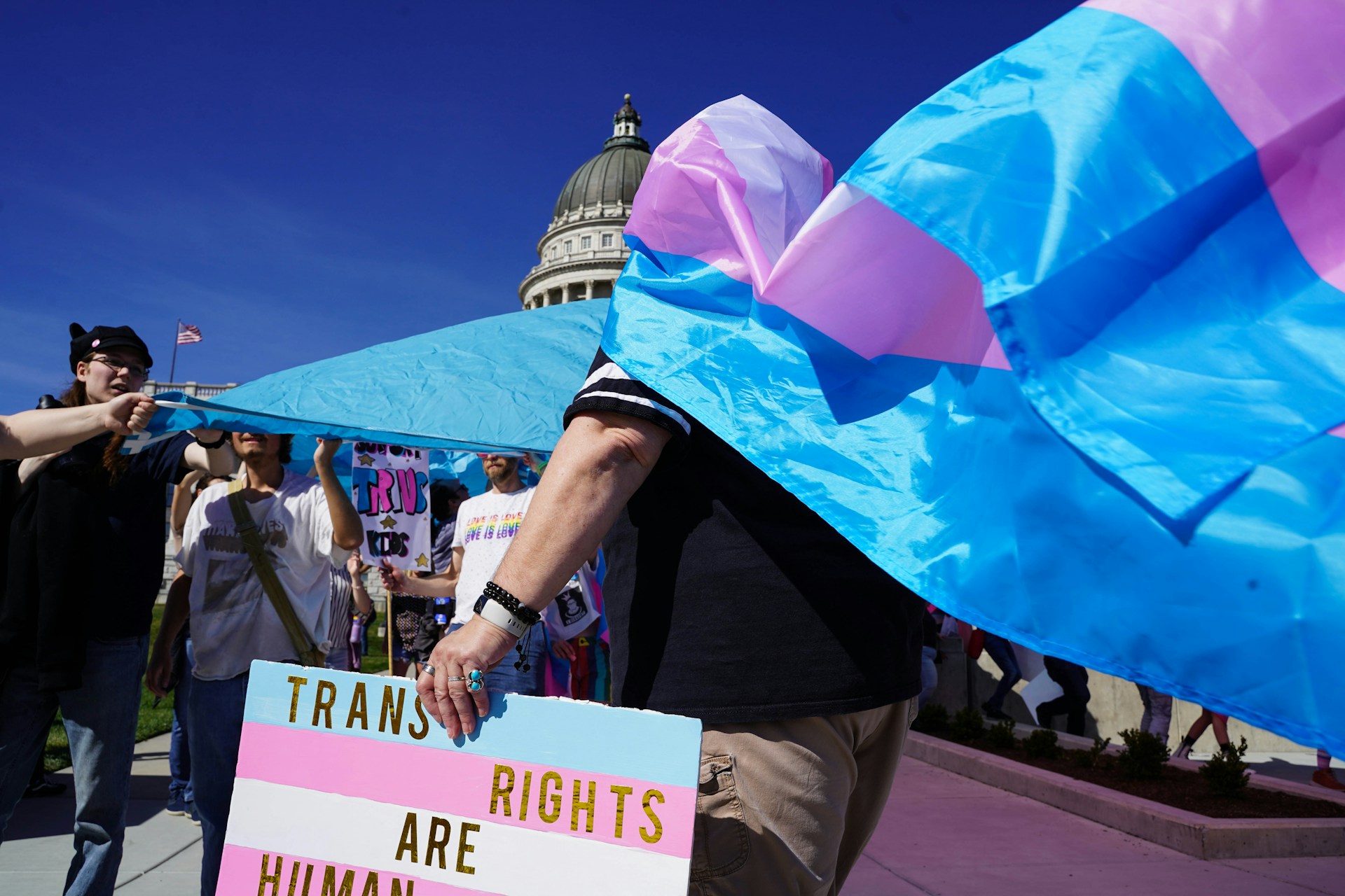 Osoba s trans zastavom na protestu